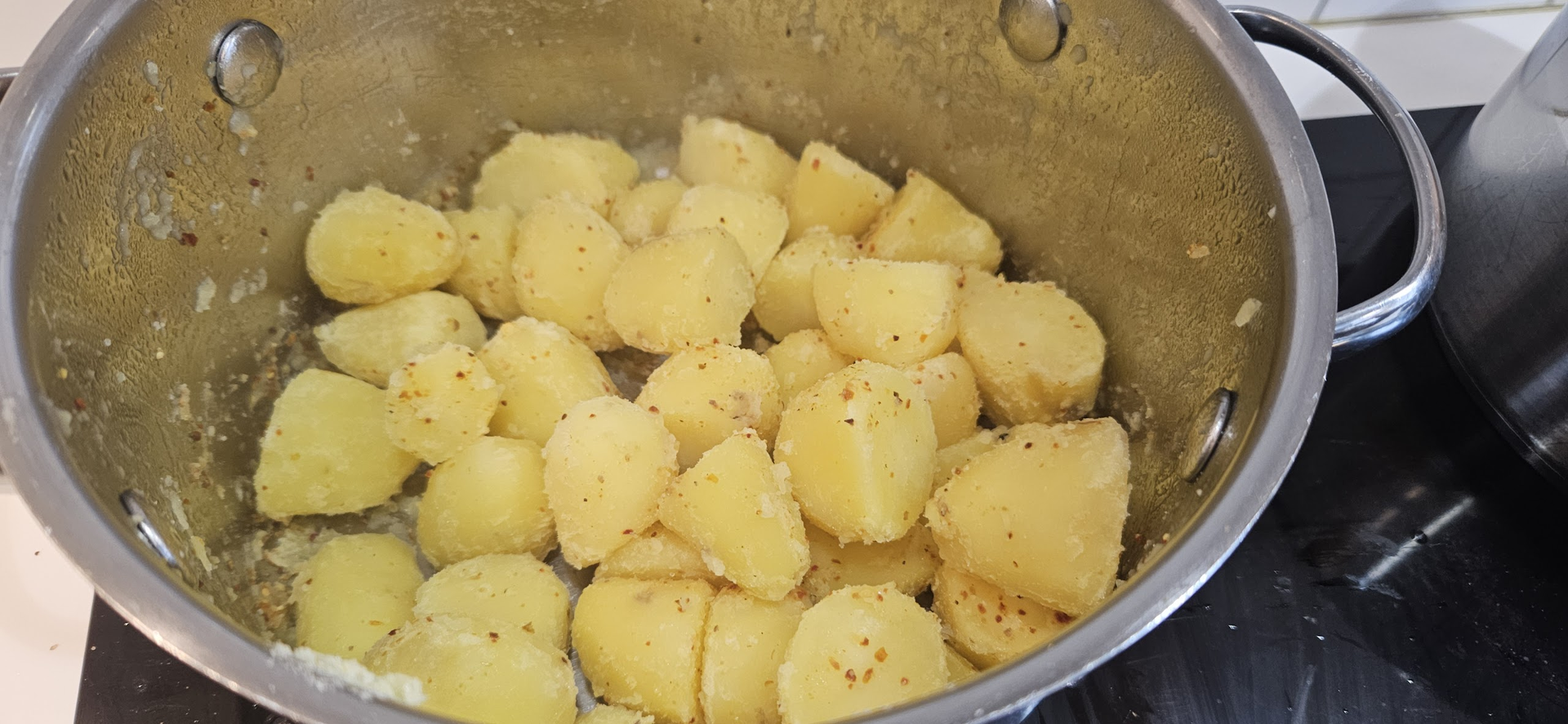 Forkok mandelpotetene, rist dem ru i bollen og vend dem med krydder så overflaten blir ekstra sprø i andefettet.