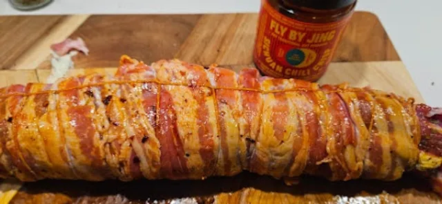 Rull sammen fileten og surr bacon tett rundt hele stykket. Pensle den så med en god chiliolje, her fra et produkt som er populært i tiden, crispy chili (den er ikke sterk!)