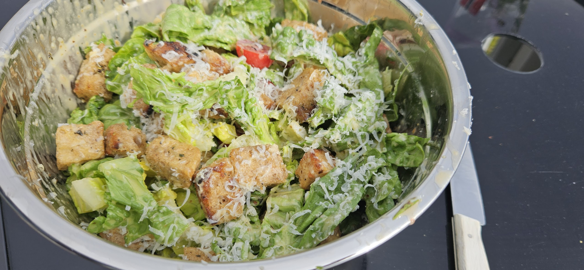 Vend salaten med dressing og grillede krutonger, og topp med parmesan.