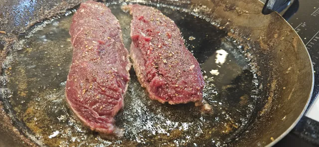 Kjøttet har forhåpentligvis fått romtemperatur, så det skal bare få en stekeskorpe før du tilsetter smør, rosmarin og hvitløk som du auser over.