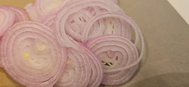 Skjær opp en sjarlottløk som senere skal friteres som garnityr.