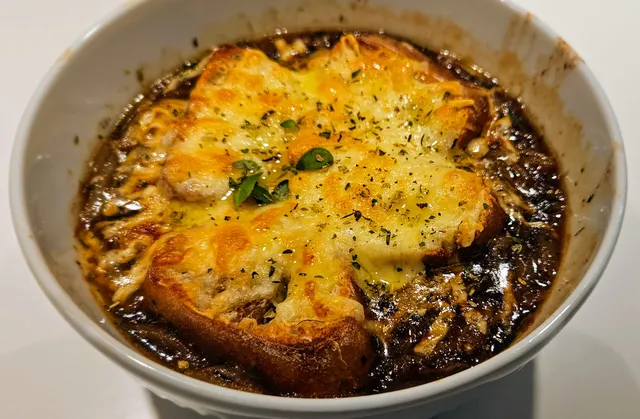 Ferdig gratinert løksuppe med ristet baguette og skarp ost på toppen.