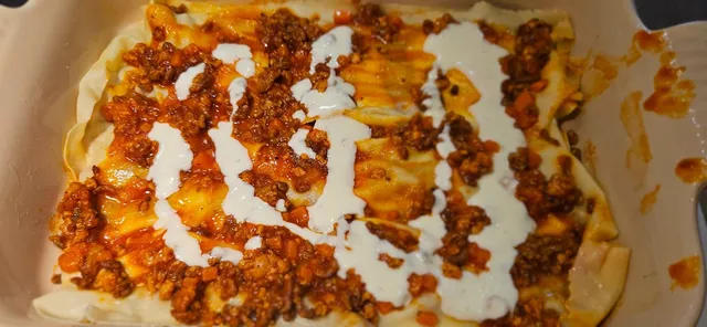 Bygg lag med pasta, ragu og ostesaus i formen.