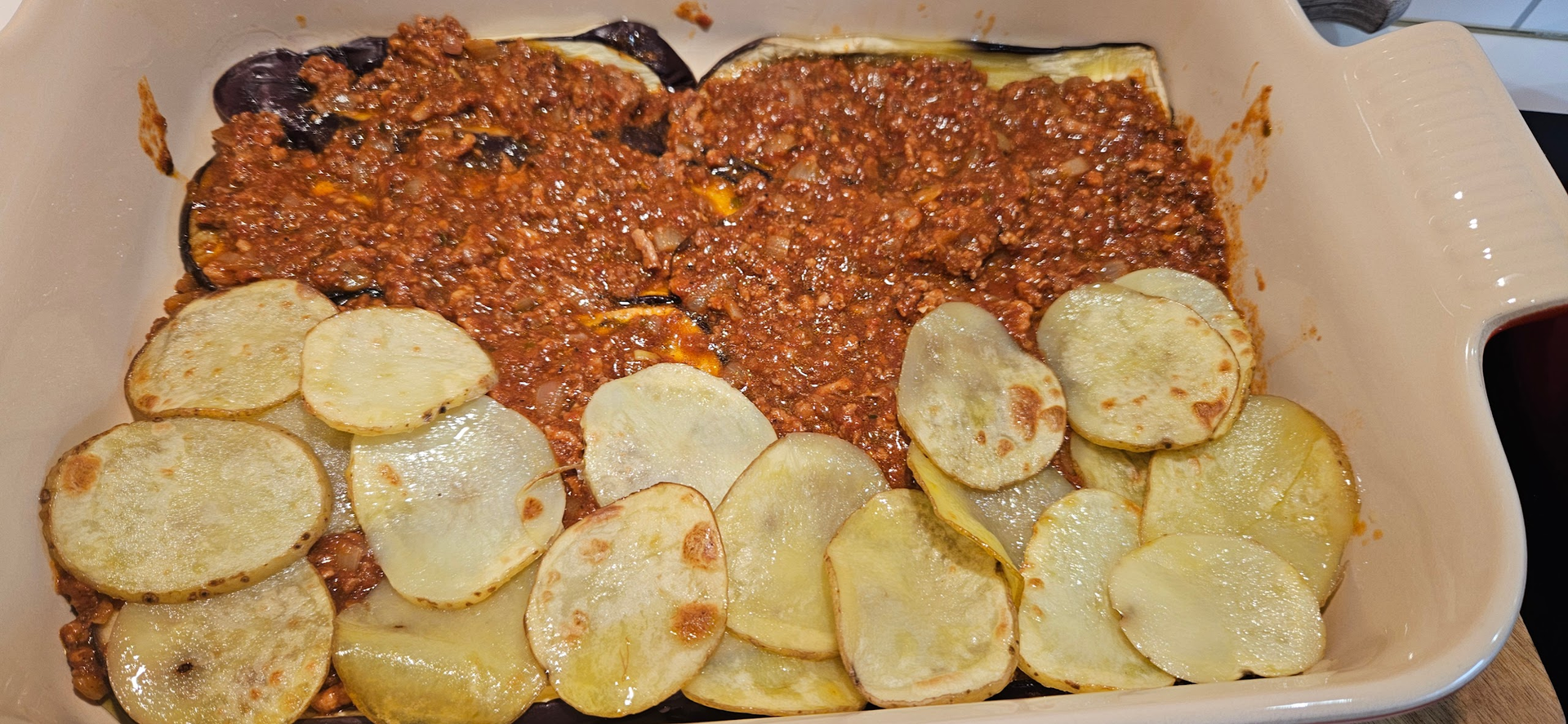 Bygg lag med potet, aubergine og kjøttsaus før formen dekkes med et tykt lag bechamel.