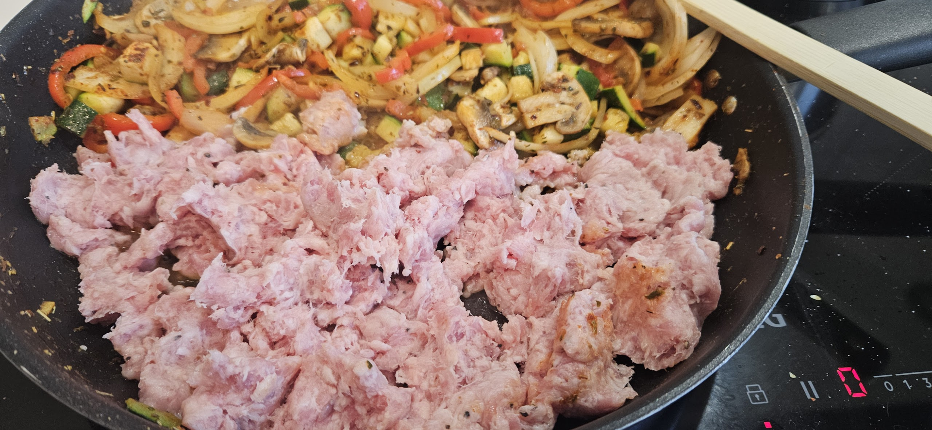 Når grønnsakene har stekt en stund, tilsetter vi salsiccia som klemmes ut av skinnet.
