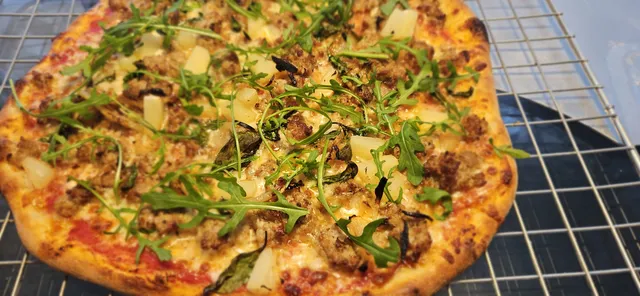 Salsicca deig som er smulet opp i biter, passer godt med stekt løk for sødme. Her har det jammen lurt seg på litt ananas og ruccula og.