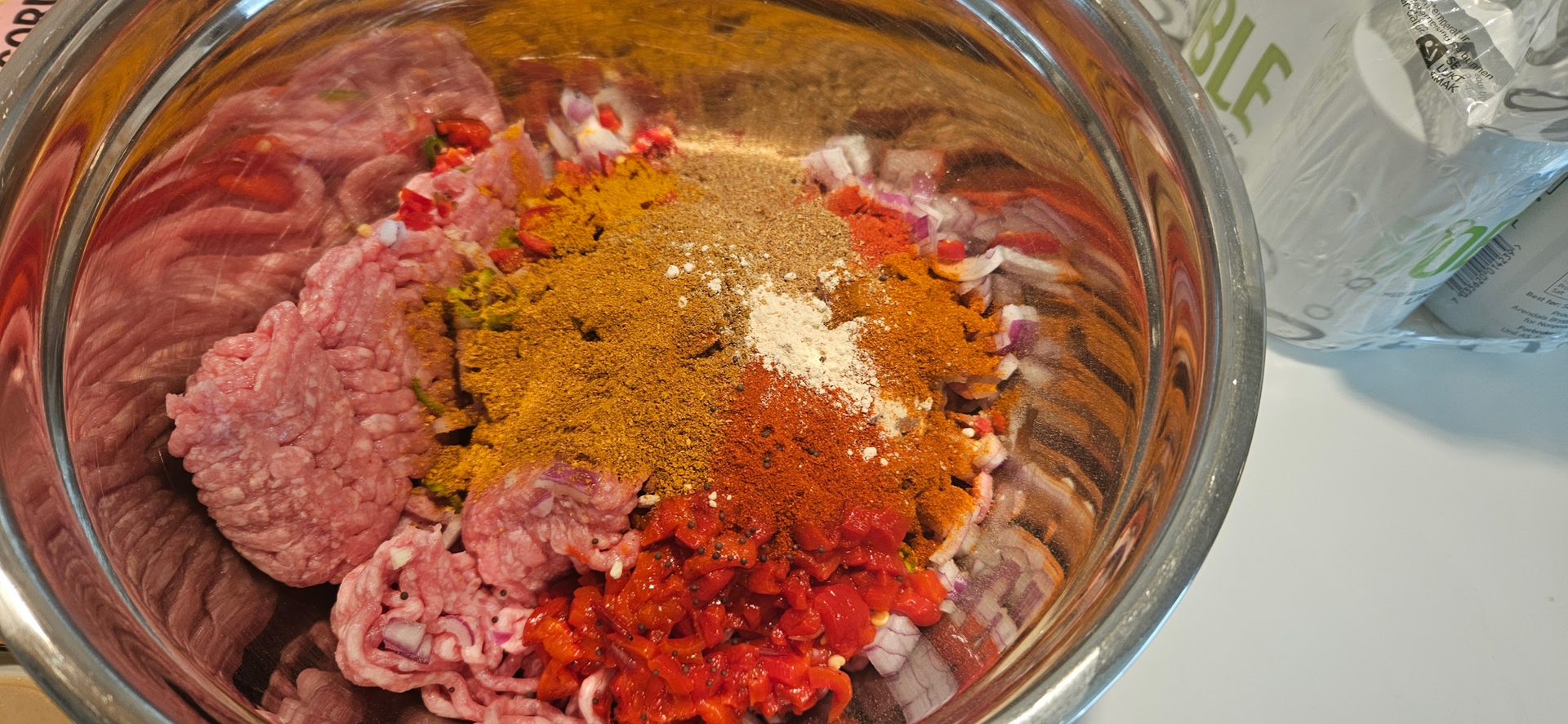 Bland lammekjøtt sammen med hakket løk, rød chilipepper, hvitløk og følgende krydder: spisskummen, koreander, ingefærpulver, røkt paprika, salt og pepper til en lett farse.