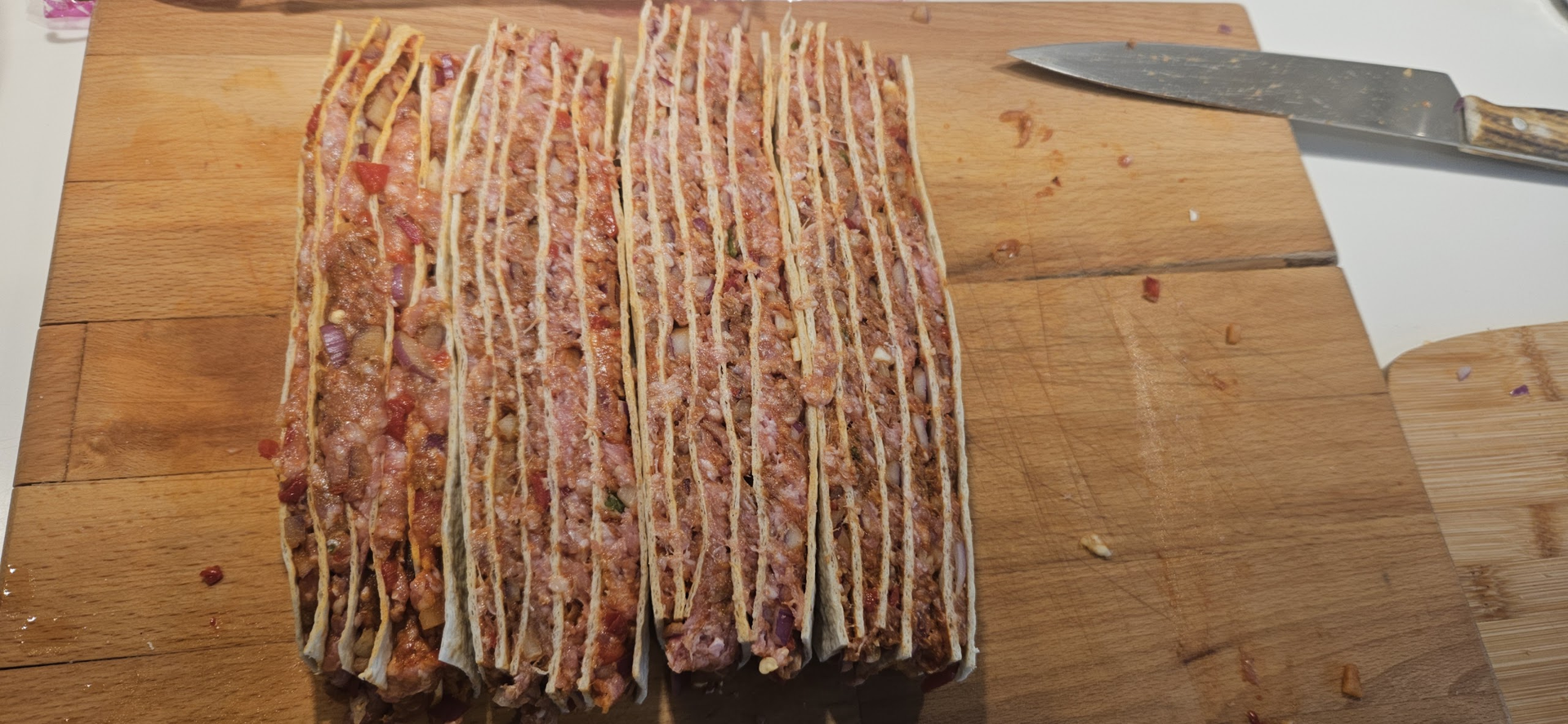 Skjær dem i ca. 3 cm brede striper, før du legger dem på høykant og skjærer dem i like tykke striper igjen. Slik får du klosser som du kan tre på grillspydet.
