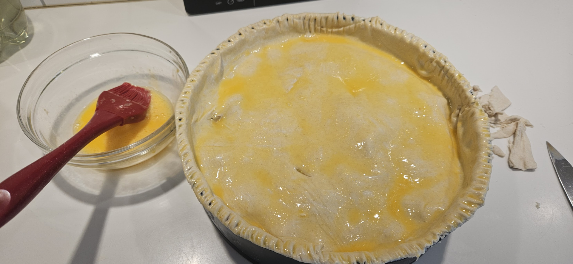 Kjevle ut to nye plater som lokk, som du så pensler med egg. Bruk gaffel til å feste lokket helt rundt. Ikke glem å stikke et par hull med kniv, slik at damp kan komme ut mens dette stekes. Sett ovnen på 220 grader.