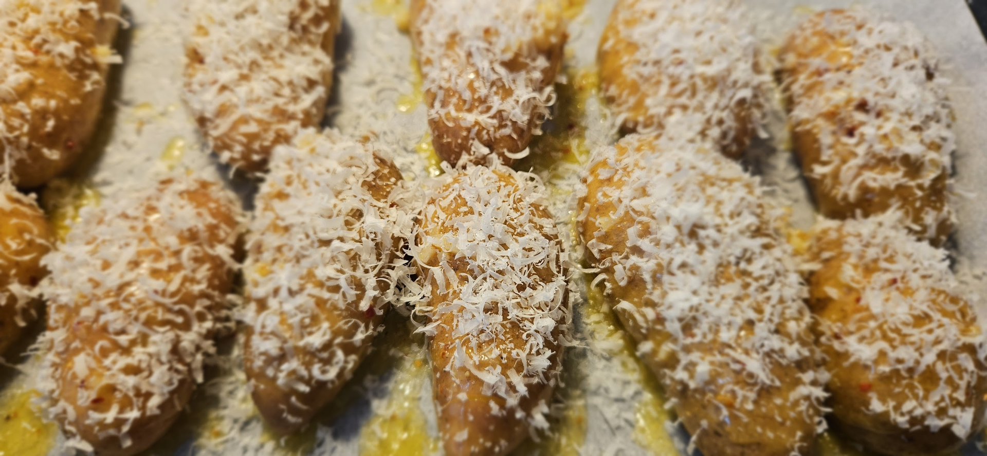 Pensle potetene med smør og hvitløk, og dekk med parmesan.