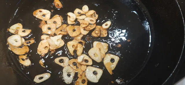 Hvitløksskivene stekes raskt i olje og legges så på tørkepapir så de blir sprø.